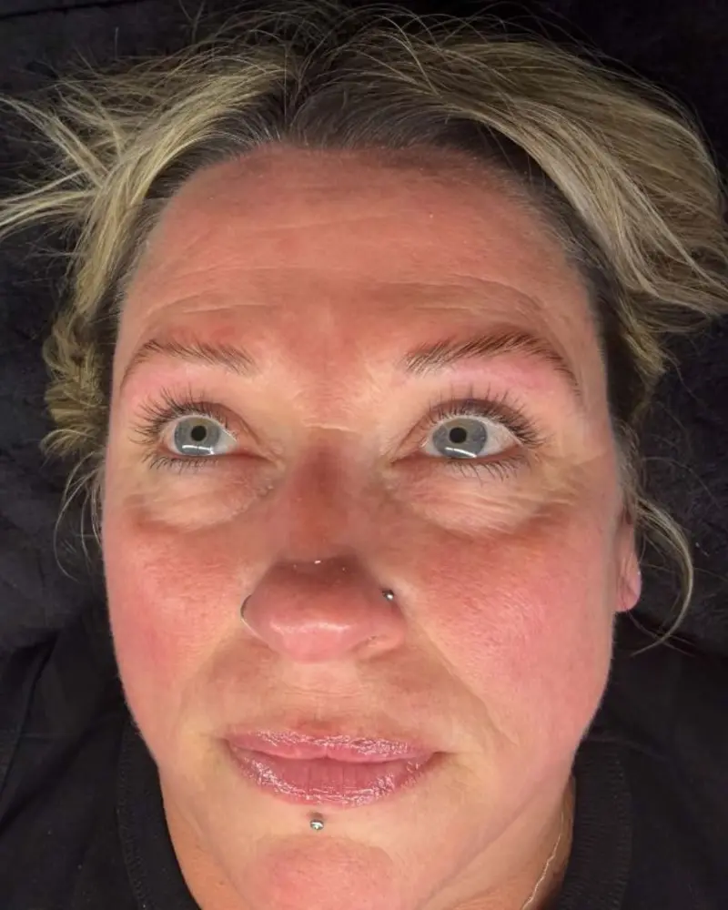Client with lifted, brushed-up brows and glossy lips lying on the treatment couch